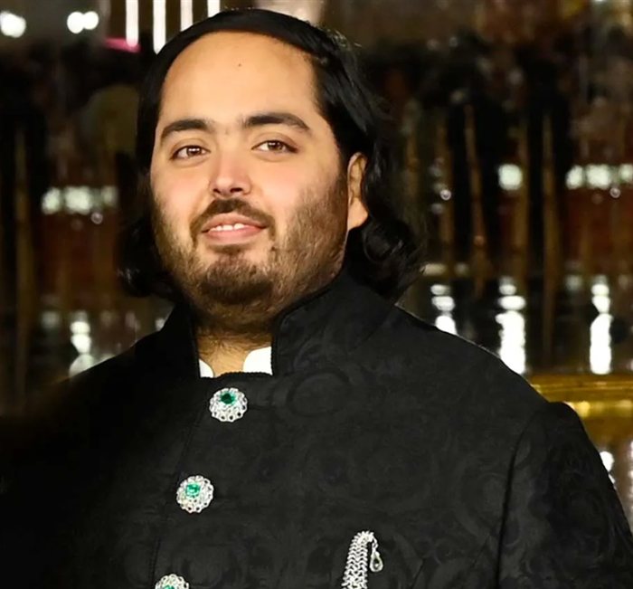 Anant Ambani smiling in a black embroidered sherwani
