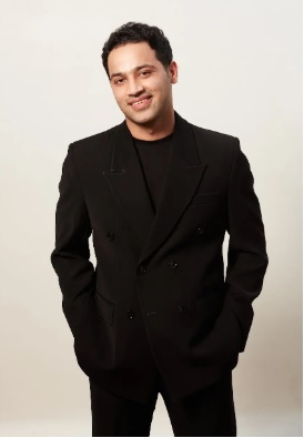 Raj Shamani smiling in a black suit